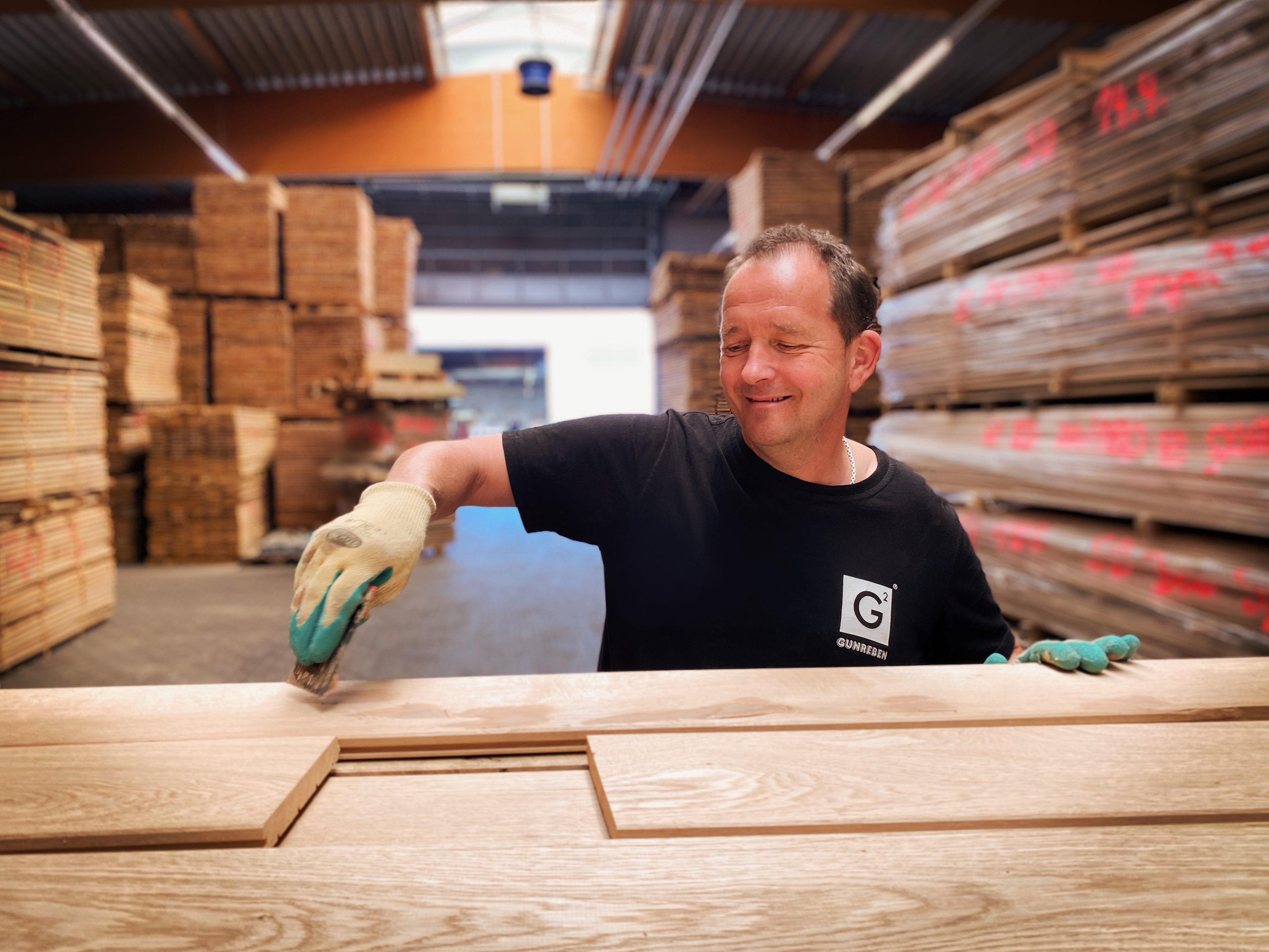 Ein Mitarbeiter von Gunreben verspachtelt Astlöcher im Massivholz-Parkett